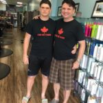 Father and son wearing matching “The Eh Team” t-shirts with a red maple leaf logo