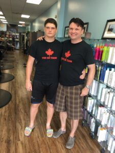 Father and son wearing matching “The Eh Team” t-shirts with a red maple leaf logo